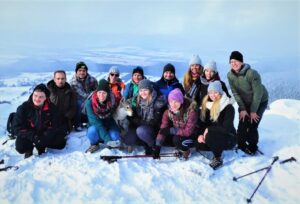 Na zdjęciu grupa ludzi pozujących do zdjęcia w zimie w górach.