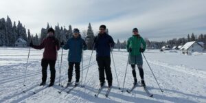 Na zdjęciu 4 osoby stoją obok siebie w nartach biegowych 