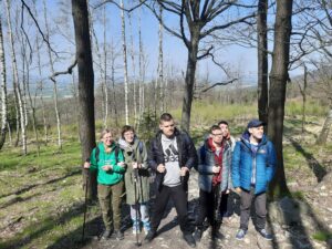 Na zdjęciu grupa 6 młodych osób stojących w lesie.