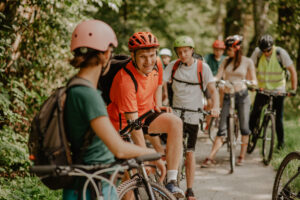 Na zdjęciu grupa osób na rowerach w lesie