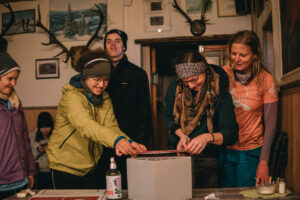 Na zdjęciu grupa 5 osób obkleja apteczkę naklejkami w schronisku górskim.