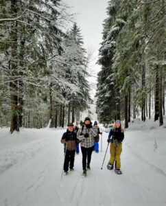 Kilka osób w zaśnieżonym lesie