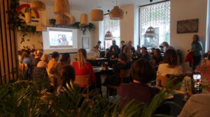 Na zdjęciu sala pełna ludzi słuchających prelekcji Agny Bieleckiej