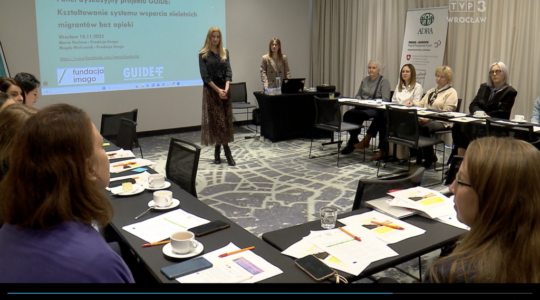 Skrinszot ze strony Faktów TVP3 Wrocław (logotyp telewizyjny jest widoczny w prawym górnym rogu). Na zdjęciu widać salę szkoleniową, przy ustawionych w podkowę stolikach siedzą uczestnicy spotkania, prze nimi rozłożone są notatki, materiały do ćwiczeń. Pośrodku sali stoją Magda Mielczarek i Mariia Pavlova z Fundacji Imago. Za ich plecami widać duży ekran z prezentacją.