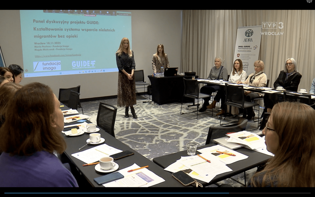 Skrinszot ze strony Faktów TVP3 Wrocław (logotyp telewizyjny jest widoczny w prawym górnym rogu). Na zdjęciu widać salę szkoleniową, przy ustawionych w podkowę stolikach siedzą uczestnicy spotkania, prze nimi rozłożone są notatki, materiały do ćwiczeń. Pośrodku sali stoją Magda Mielczarek i Mariia Pavlova z Fundacji Imago. Za ich plecami widać duży ekran z prezentacją.