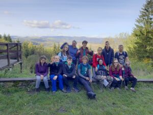 Na zdjęciu grupa młodych osób pozuje do zdjęcia na tle gór