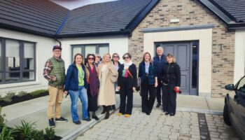 10-osobowa grupa pozuje do zdjęcia na świeżym powietrzu, w tle widać jednopiętrowy budynek. Wśród osób na zdjęciu są Martyna Rangno i Michał Lemański z Fundacji Imago.