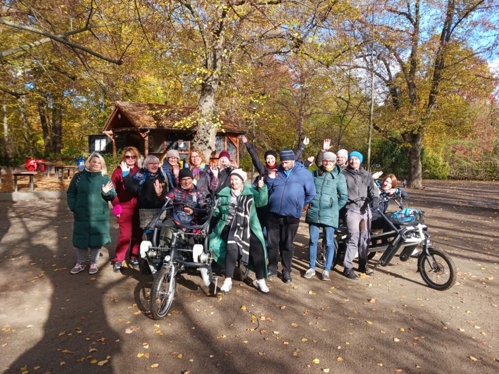 Grupa robocza projektu Mam tę moc pozuje do zdjęcia w parku, z rowerem - tandemem Fan tu goł.