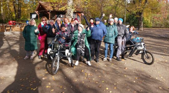 Grupa robocza projektu Mam tę moc pozuje do zdjęcia w parku, z rowerem - tandemem Fan tu goł.