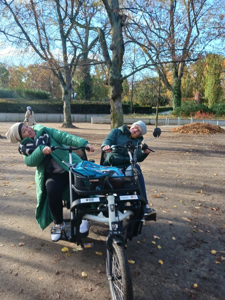 Dwie uśmiechnięte osoby na rowerze - tandemie Fan tu goł.