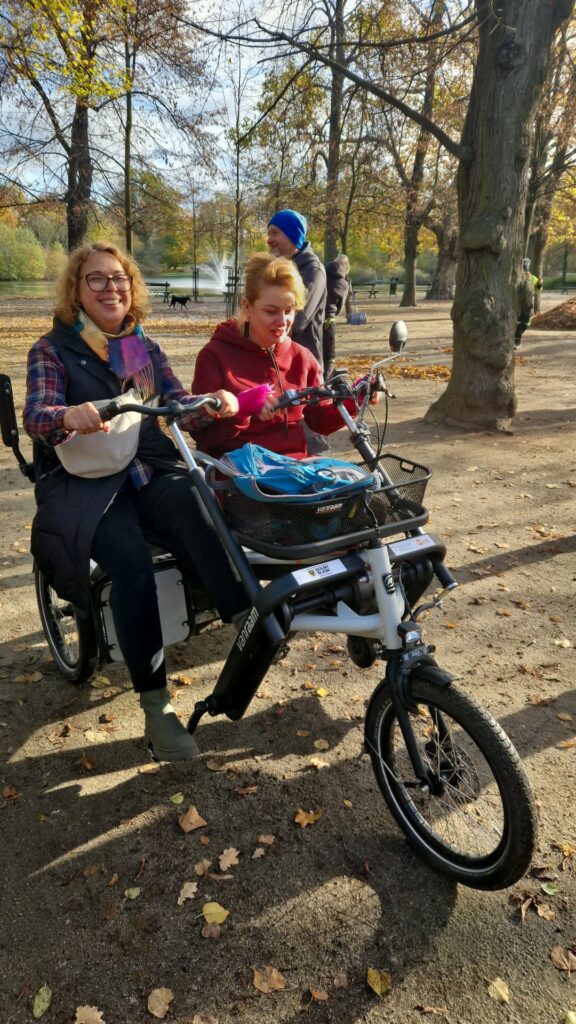 Dwie uśmiechnięte osoby na rowerze - tandemie Fan tu goł.