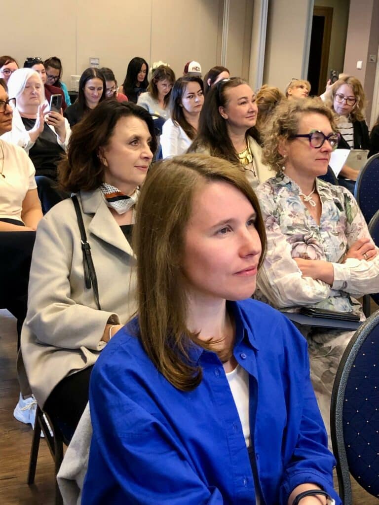 Sala konferencyjna. Uczestnicy konferencji słuchają prezentacji.