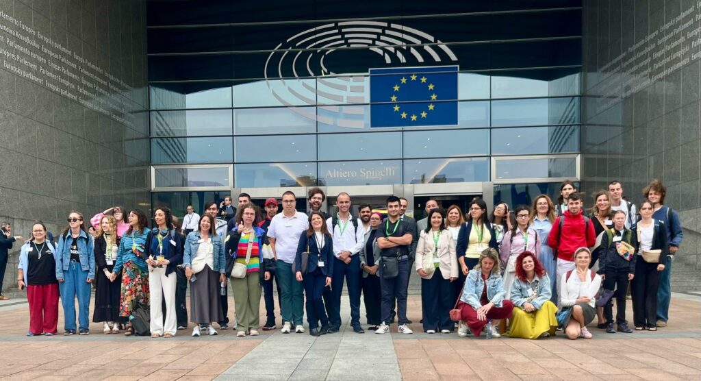 Kilkadziesiąt osób pozuje do zdjęcia naprzeciwko budynku Parlamentu Europejskiego w Brukseli. To uczestnicy, koordynatorzy i wolontariusze projektu Points of konekszyn. Wśród nich jest grupa z Polski.