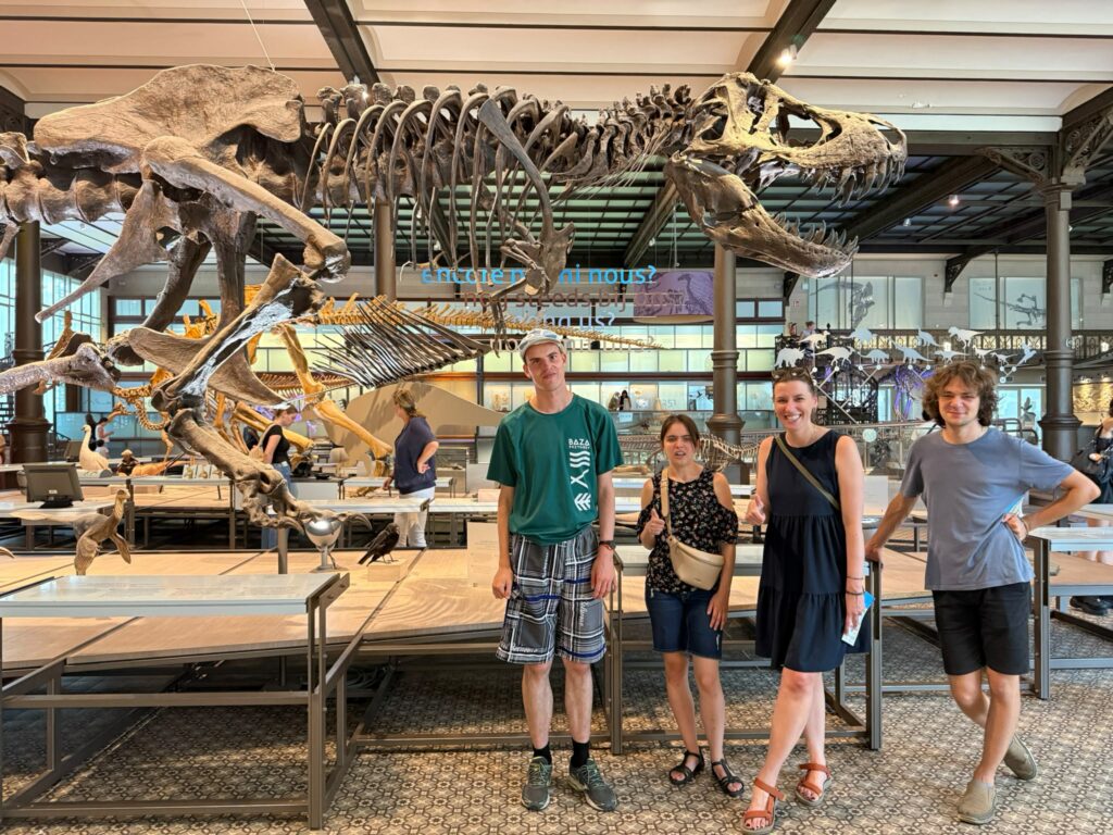 Uczesnicy, koordynatorka i wolontariusz polskiej grupy projektu Points of konekszyn pozują do zdjęcia w Muzeum Historii Naturalnej w Brukseli przy szkielecie dinozaura.