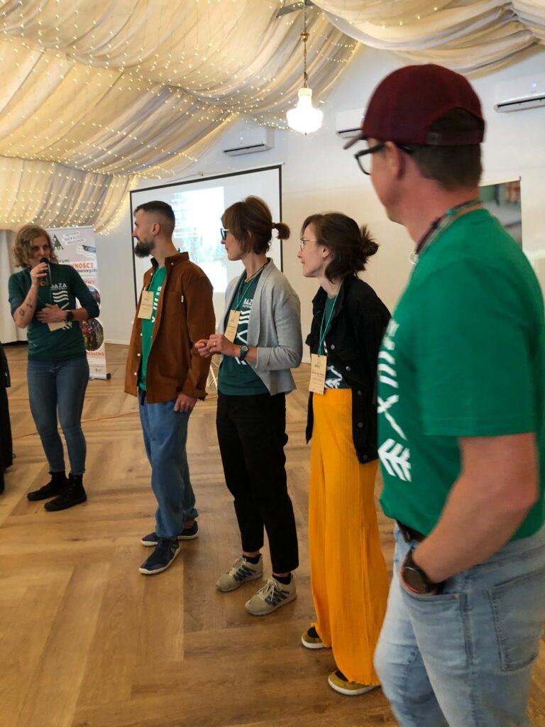 Prelegenci i prowadzący warsztaty w czasie konferencji "Natura bez barier": Agata Włodarczyk, Wojciech Walkarz, Magdalena Stempska, Magda Kowalska, Michał Lemański. Stoją obok siebie w namiocie konferencyjnym, rozpoczynając konferencję.