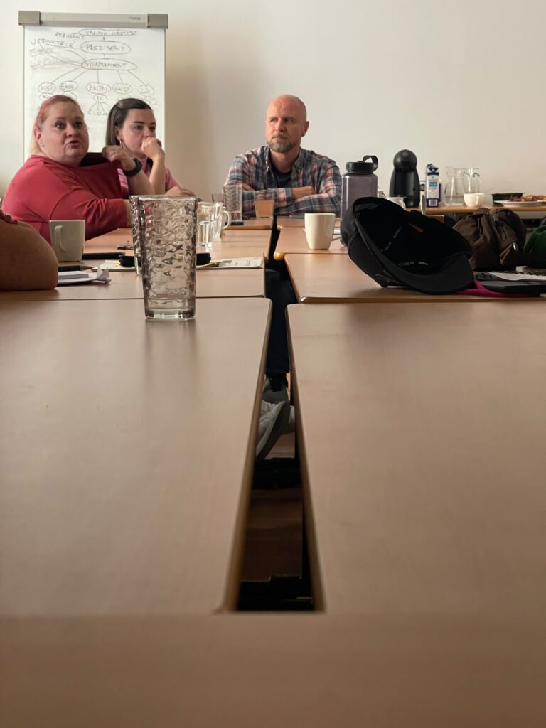 Sala z podłużnym stołem, przy którym siedzą gospodarze wizyty studyjnej w Czechach.