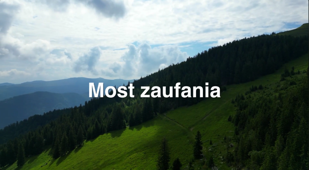 Zdjęcie górskiego krajobrazu z białym napisem: Most zaufania.