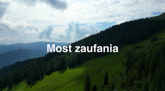 Zdjęcie górskiego krajobrazu z białym napisem: Most zaufania.