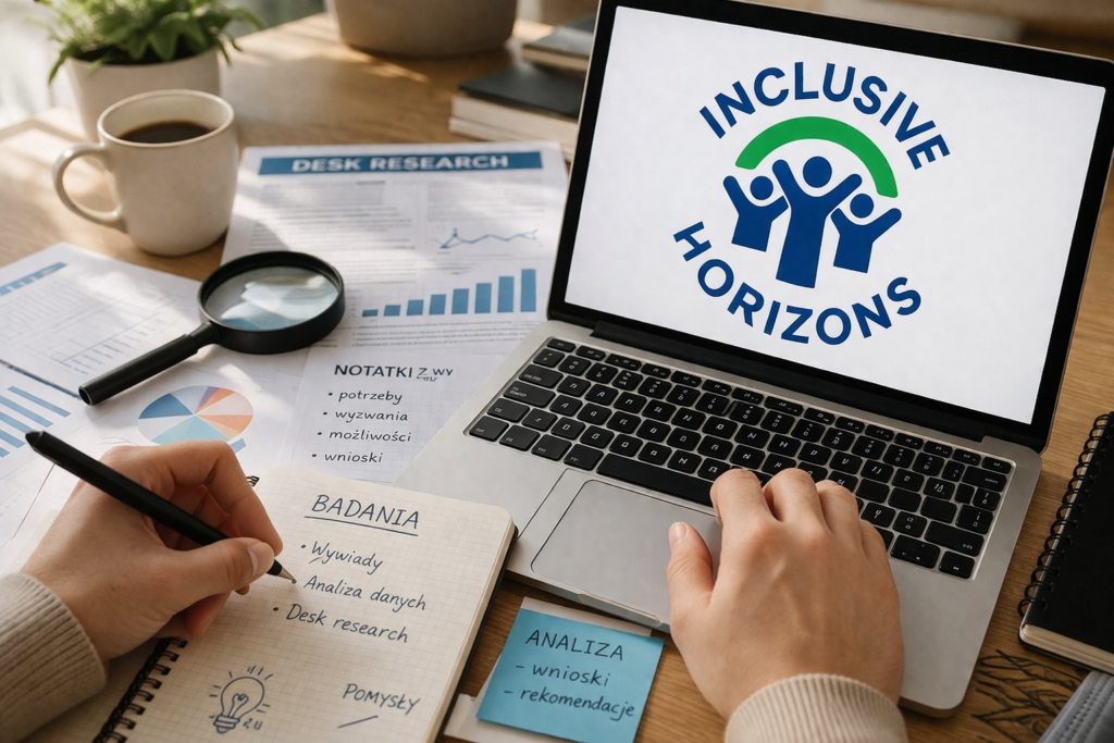 Biurko, na biurku notatki i ekran komputera z wyświetlonym logotypem projektu Inklusif Horizons. Na zdjęciu widać też ręce osoby siedzącej przy komputerze. 